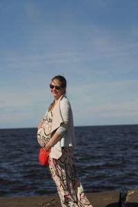 Smiling pregnant women, touch belly