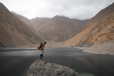 Man standing on rock against mountains