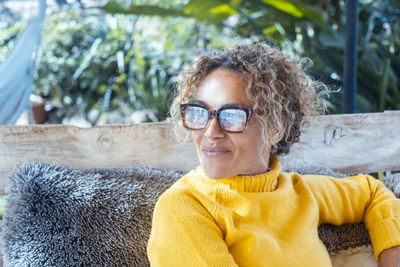 Portrait of young woman wearing sunglasses standing outdoors