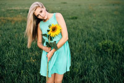 Portrait of young woman standing on field