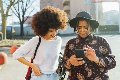 Young woman using mobile phone in city