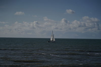 Sailboat sailing on sea against sky