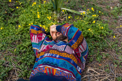 Moroccan man laying on the ground with his hand over his face