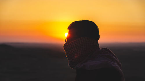 Silhouette of man standing against sky during sunset