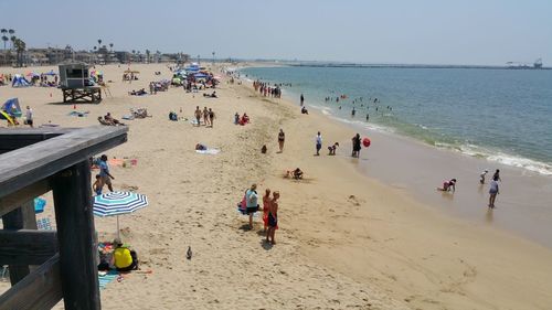 People playing at beach against clear sky