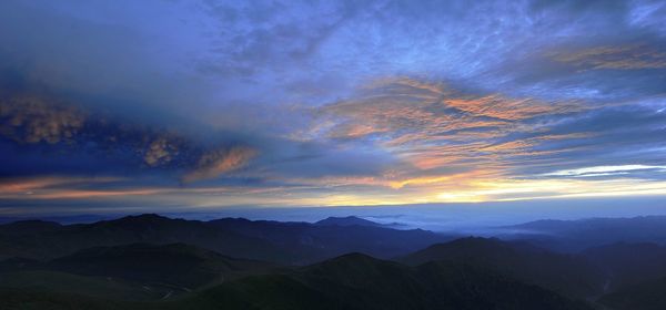 Scenic view of mountains against cloudy sky