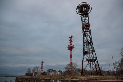 Low angle view of communications tower and building against sky