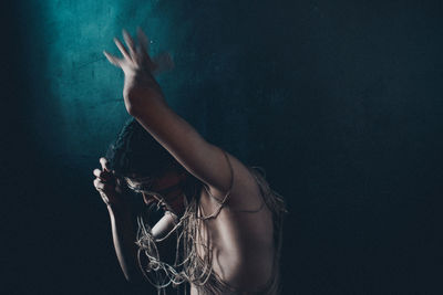 Side view of woman hand against black background