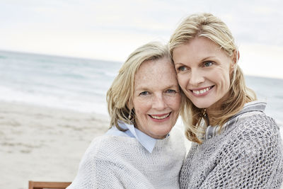 Mother and daughter embracing on the beach