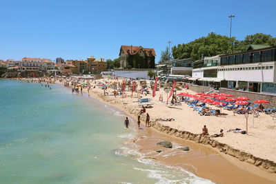 People on beach against clear sky