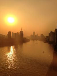 Sunset over river with buildings in background