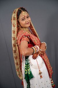 Portrait of a smiling young woman standing against wall