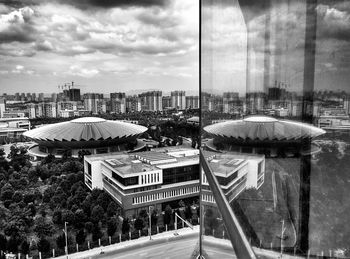 Buildings in city against cloudy sky