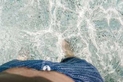 Low section of man standing in water