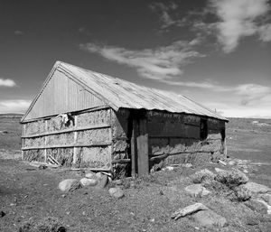 Damaged building on field against sky