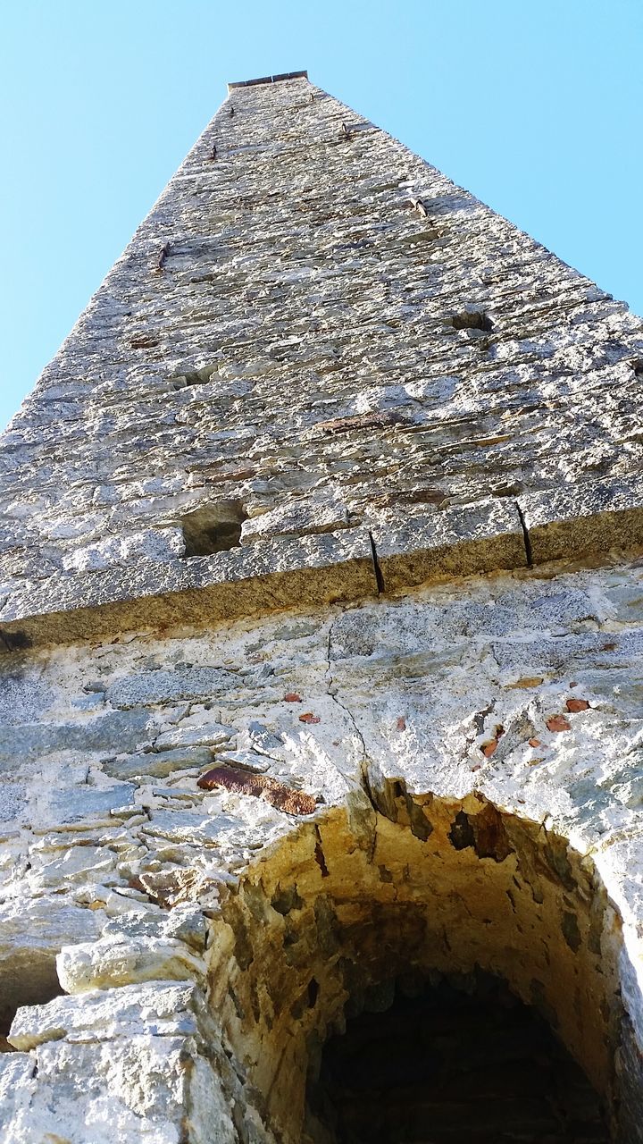 clear sky, building exterior, built structure, architecture, blue, stone material, rock - object, low angle view, history, stone wall, old, sky, the past, day, sunlight, outdoors, stone - object, no people, textured, stone