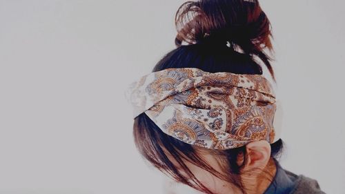 Close-up of woman wearing headwear over white background