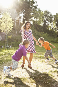 Portrait of a happy mother playing with children in park