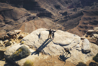 Aerial view of a family standing on a cliff of a utah canyon