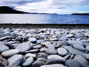 Stones on beach against sky
