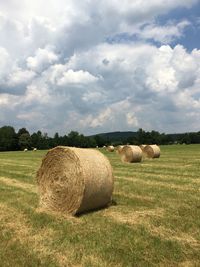 Scenic view of grassy field against cloudy sky