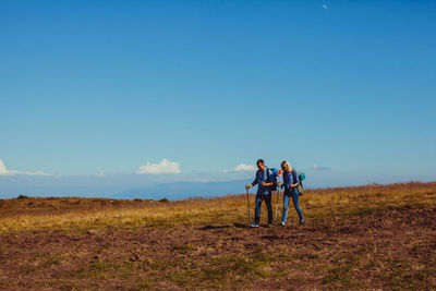 Men standing on field against sky