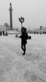 People on beach in city against sky during winter