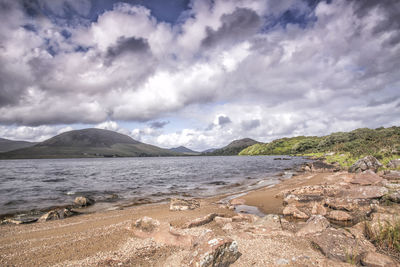 Scenic view of sea and mountains against sky