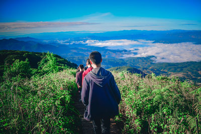 Rear view of woman on mountain against sky