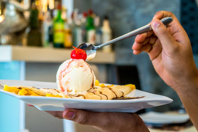 Close-up of woman eating fresh dessert at restaurant
