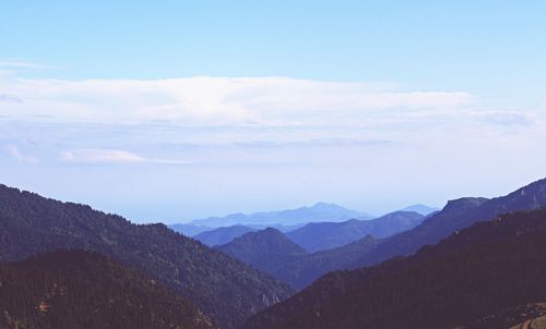 Scenic view of mountains against cloudy sky