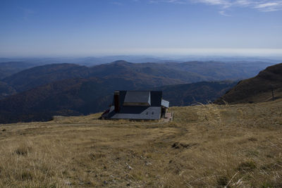 Scenic view of field and mountains against sky