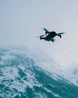 Low angle view of drone flying against clear sky