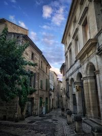 Street amidst buildings in town against sky