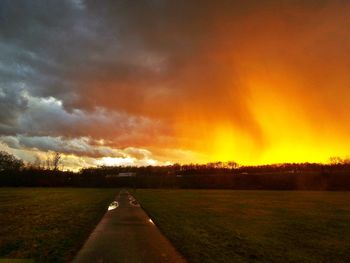 Road amidst landscape against dramatic sky