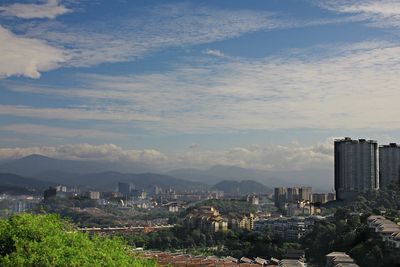 View of cityscape against cloudy sky