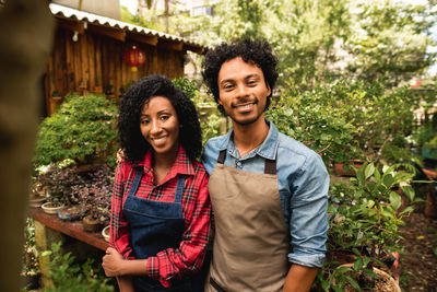 Portrait of couple standing and smiling at plant nursery