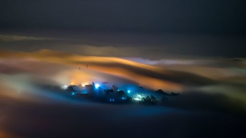 Illuminated city against sky at night