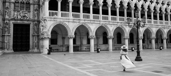 Woman walking on saint mark's square in front of doge's palace in venice