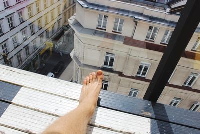 Low section of woman on building in city