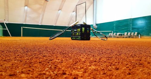 Tennis rackets and container on court