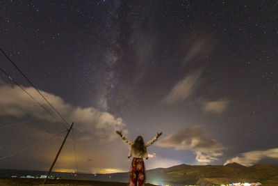 Low angle view of man standing against sky at night