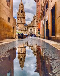 Reflection of building on street in city