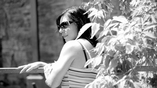 Side view of a young woman sitting on plant