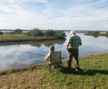 Rear view of couple fishing at lake