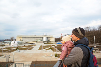 Midsection of mother with daughter against sky