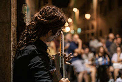 Midsection of woman playing outdoors at music concert