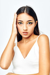 Portrait of young woman against white background