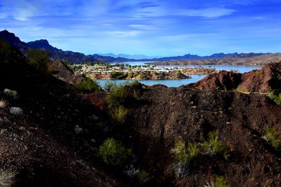 Scenic view of mountains and river against blue sky