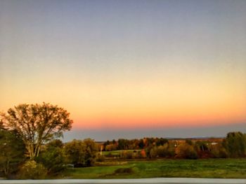 Scenic view of field against clear sky during sunset